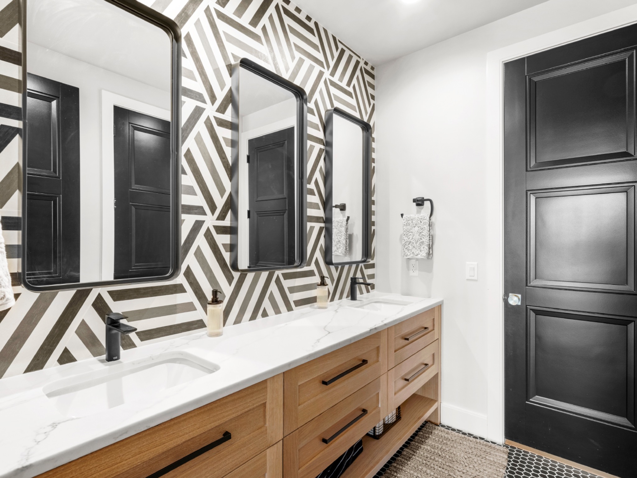 Bathroom with geometric accent wall and black fixtures